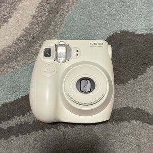 White Polaroid camera. Comes with a pink case, and 9 Polaroids in the camera